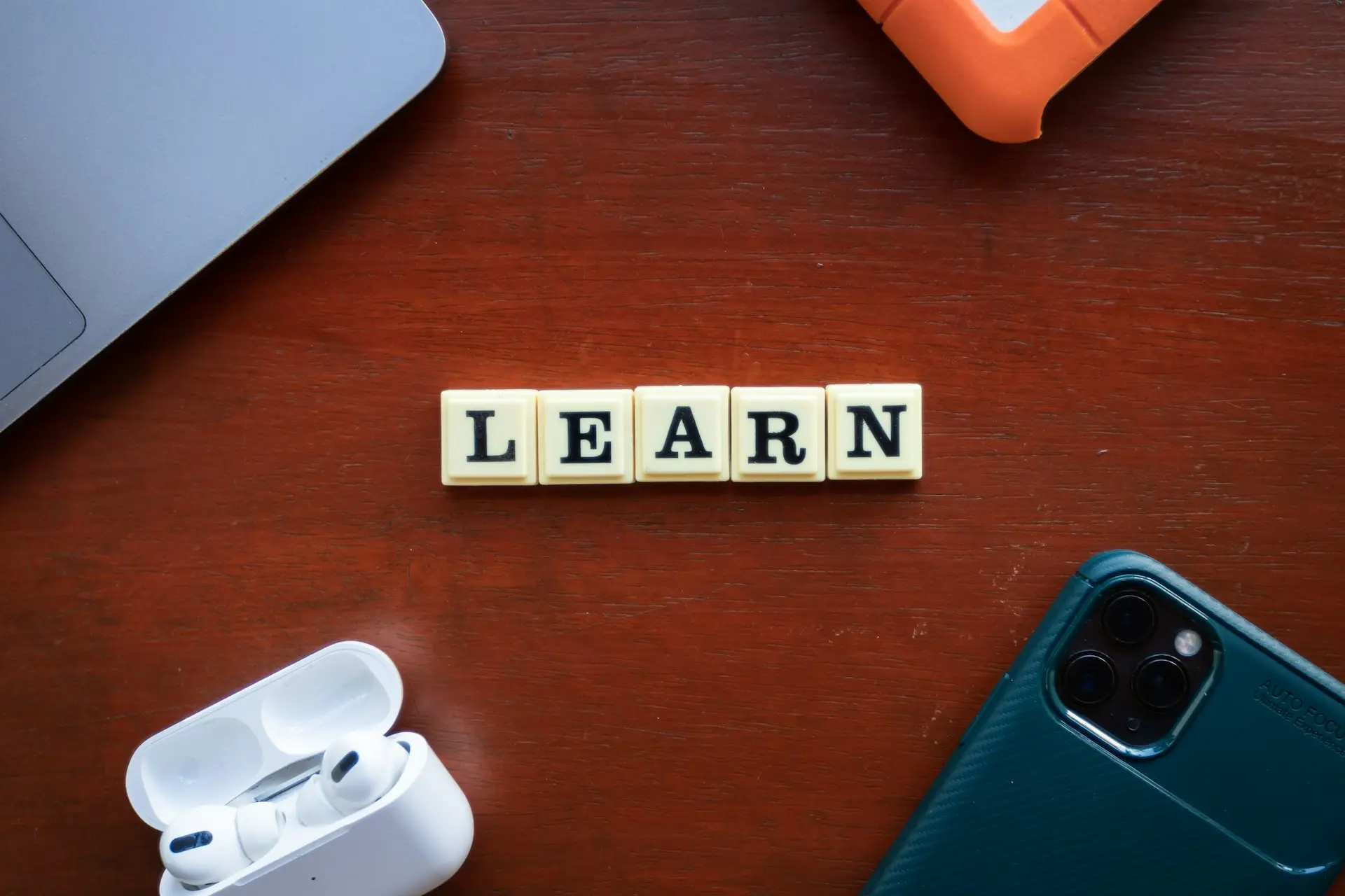 the word learn spelled with scrabble letters on a wooden table